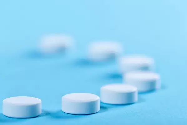 White round pills on blue background (Flip 2019)