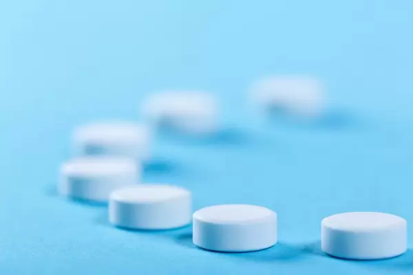 White round pills on blue background