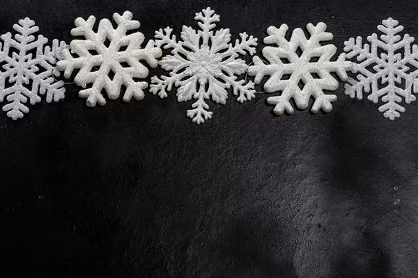 White snowflakes on a black background. Free space