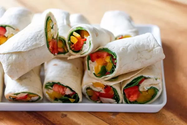 White tray with vegetable and chicken wraps