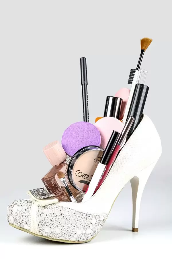 White women's shoe filled with cosmetics