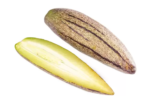 Whole and half pepino fruit on white