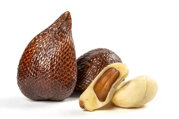 Whole and peeled snake fruits on white background