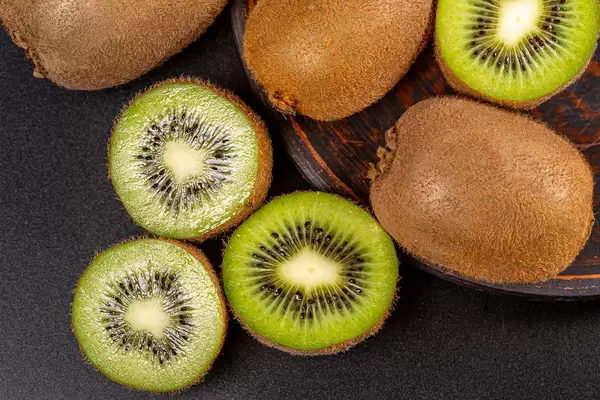 Whole and sliced kiwi fruit, top view