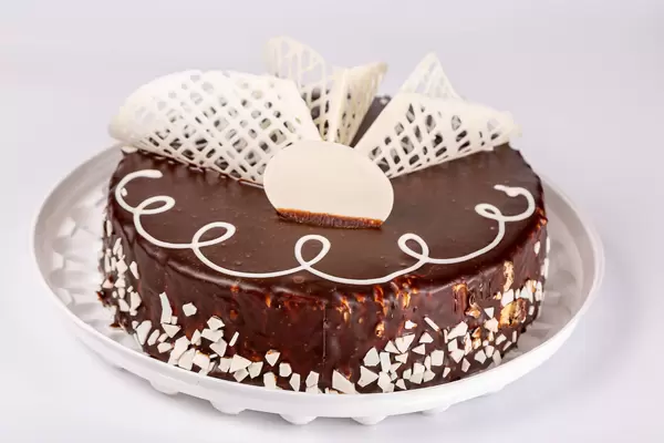 Whole brown chocolate cake with white chocolate decor