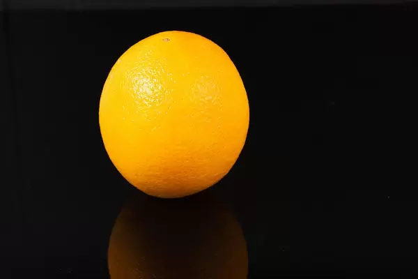 Whole Orange fruit above reflective black background (Flip 2019)