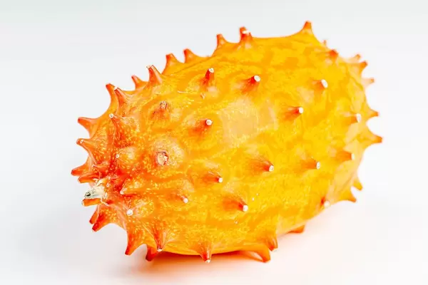 Whole orange kiwano fruit on white background