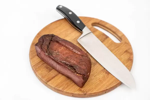 Whole piece of Smoked Ham on the wooden cutting board