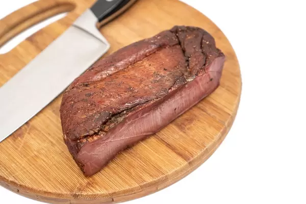 Whole piece of Smoked Ham witk knife on the wooden board (Flip 2020)