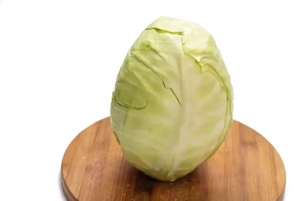 Whole raw cabbage on the wooden board
