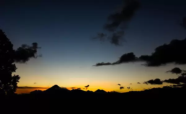 Wide view of colorful sunset behind Guatemala's volcanoes