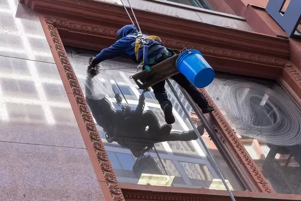 Window cleaner attached to a rope system cleans the windows of a building in Chicago