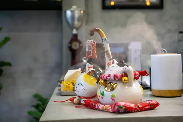 Winkende Katze als Glücksbringer und Luftbefeuchter in einem Cafe