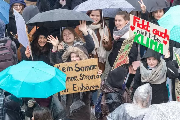 Winkende Studenten mit dem Schild 'Kein Sommer, Sonne, Strand für Eisbären' auf Fridays For Future Umweltprotest