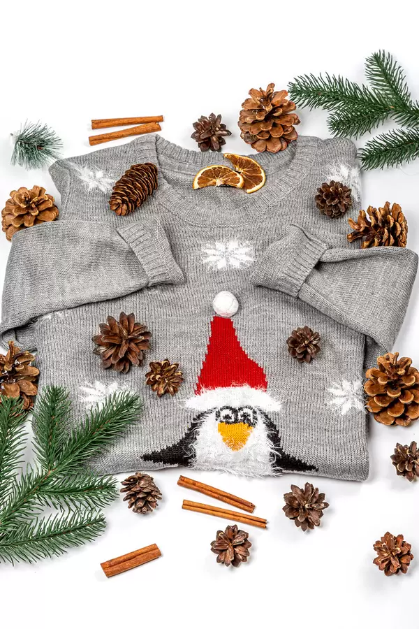 Winter background with sweater, christmas tree branches and pine cones on white