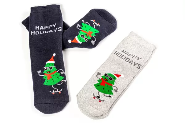 Winter warm socks with christmas trees and happy holidays lettering
