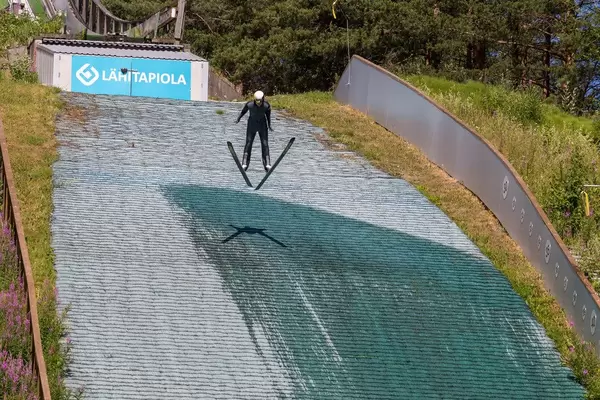 Wintersportler trainiert das Skispringen im Sommer in der Schanzenanlage von Lahti, Finnland