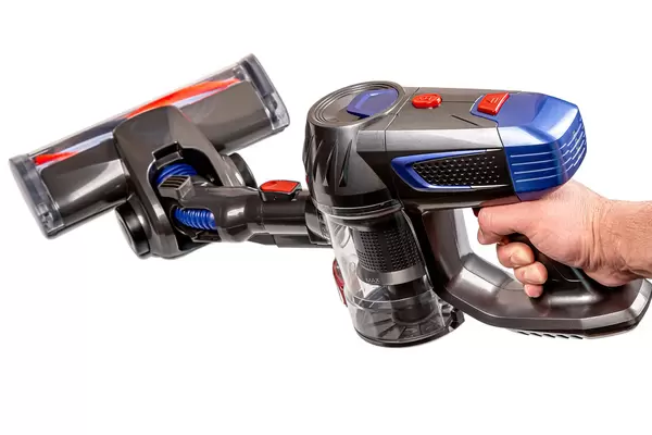 Wireless upright vacuum cleaner in man hand, house cleaning equipment tool