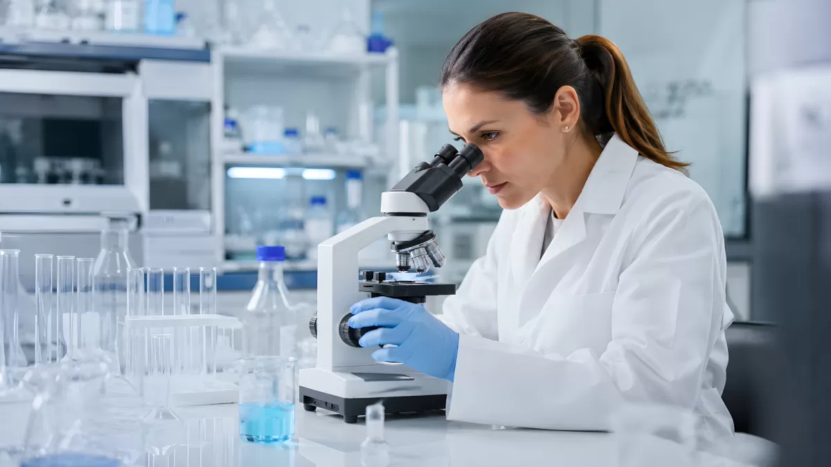 Wissenschaftlerin analysiert Probe unter dem Mikroskop