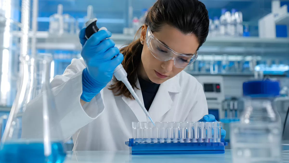 Wissenschaftlerin pipettiert Proben in Reagenzgläser