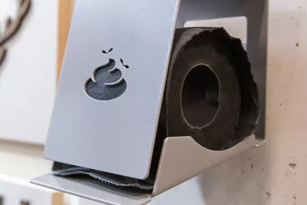 Witziger Toilettenpapierhalter mit Motiv in Form von Häufchen mit Fliegen mit schwarzem Papier