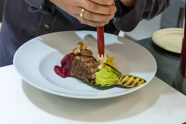 WMF Koch und Foodartist serviert ein gutaussehendes Mittagessen mit Fleisch und Gemüse