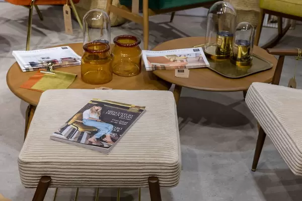 Wohnzimmertisch mit Dekoration und Hocker im Stil der 60er-Jahre mit Zeitschrift