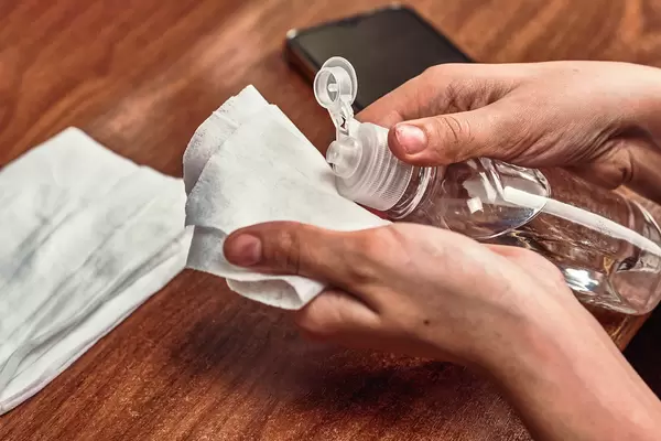 Woman applying antiseptic gel onto wipe