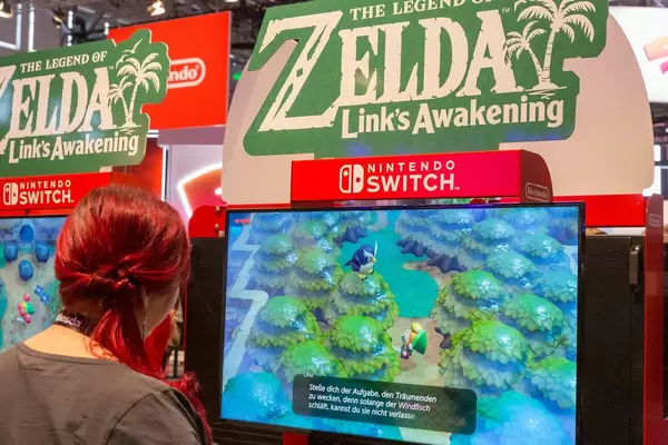 Woman at the games fair Gamescom in Cologne, playing the remake of The Legend of Zelda - Link's Awakening"