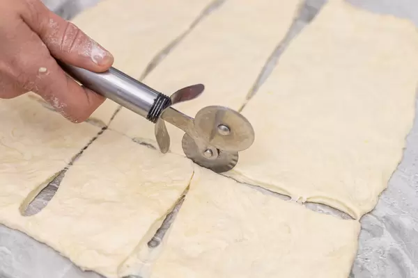Woman cutting Raw Dough on the table and preparing cookies