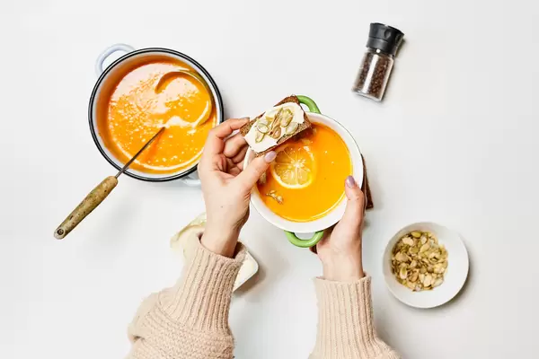 Woman eating freshly prepared pumpkin soup