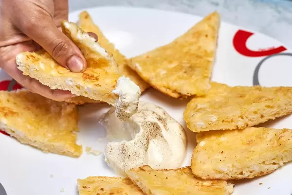 Woman eating gluten-free breakfast - rice-flour based khachapuri