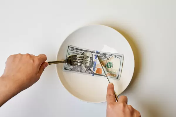 Woman eating hundred dollar bill for dinner