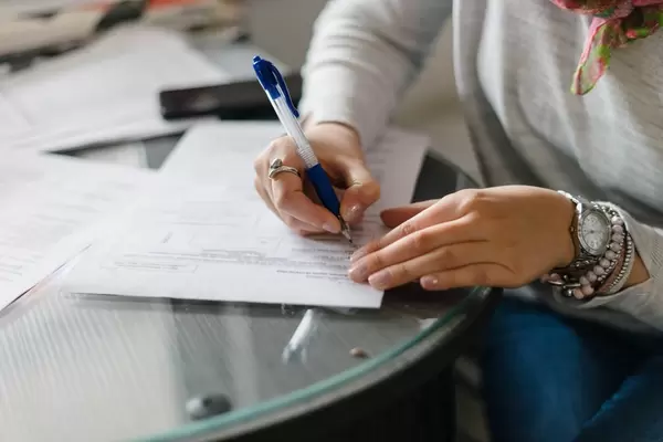 Woman Filling Up The Documents in the Office