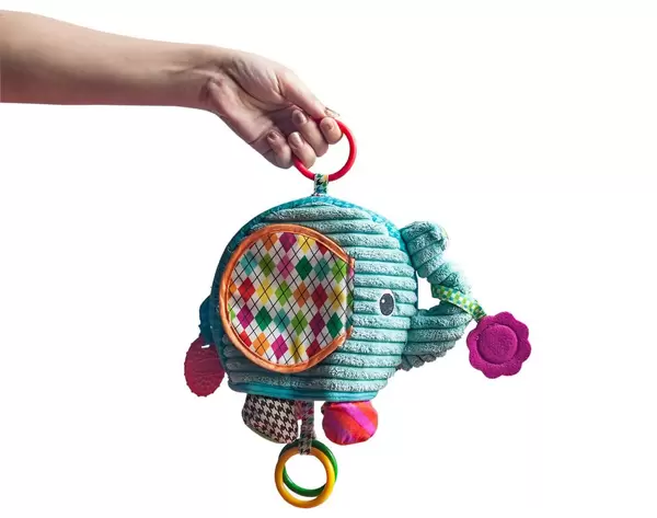 Woman hand holding elephant rattle. Isolated on white background