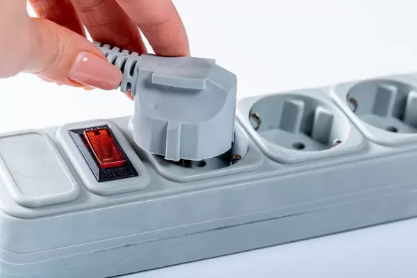 Woman hand plugging in appliance to portable socket