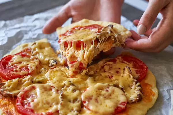 Woman hand takes a slice of pizza slice