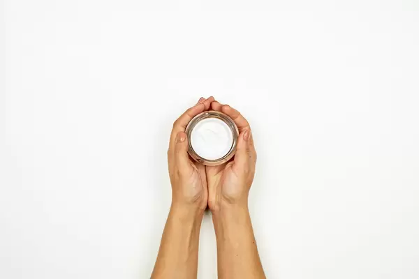 Woman hands holding a cream jar