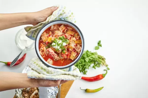 Woman holding a bowl of borsch - traditional soup of Russian cuisine