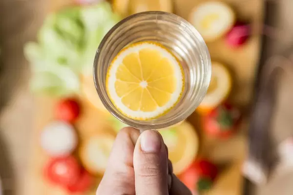 Woman holding a glass of lemon water (Flip 2019)