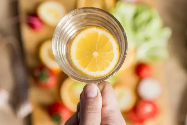 Woman holding a glass of lemon water
