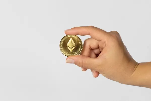 Woman holding a physical Ethereum coin