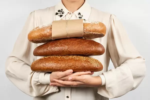 Woman holding a pile of breads
