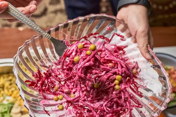Woman holds a plate of healthy beet salad