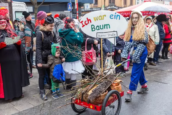 Woman in construction worker's costume at the Shrove Monday procession, deals with tree felling for the construction for a light rail system in Cologne