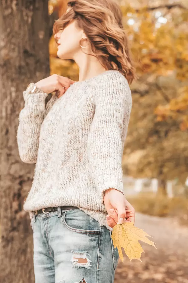 Woman in knitted sweater on autumn background