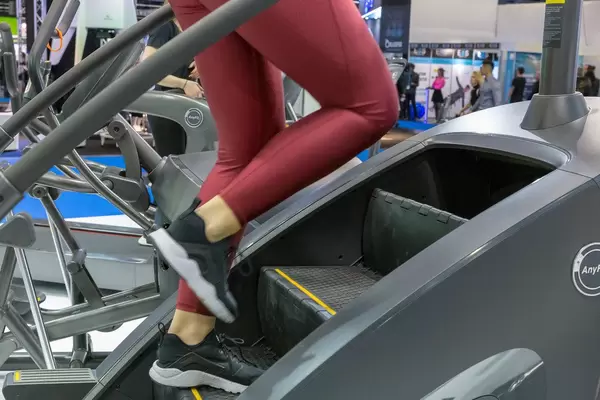 Woman in red leggings trains at an AnyFit step machine at the fitness trade show in Cologne
