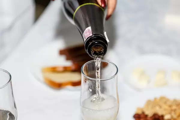Woman pouring sparkling wine into the glass (Flip 2019)