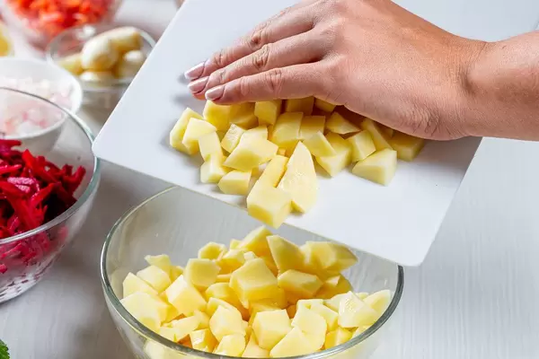 Woman pours sliced potatoes in a glass bowl (Flip 2019)