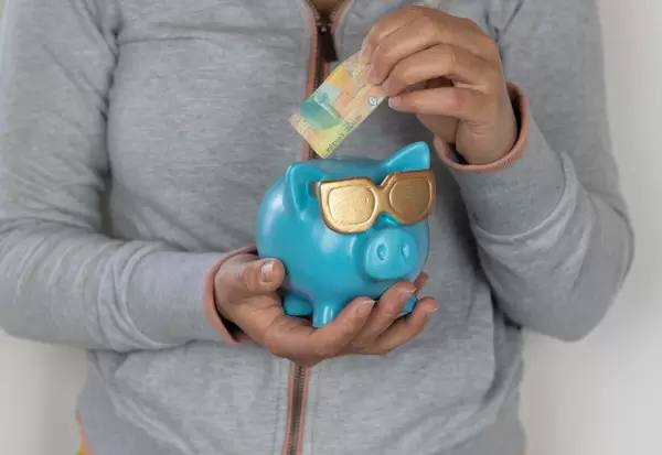 Woman putting money into a piggy bank